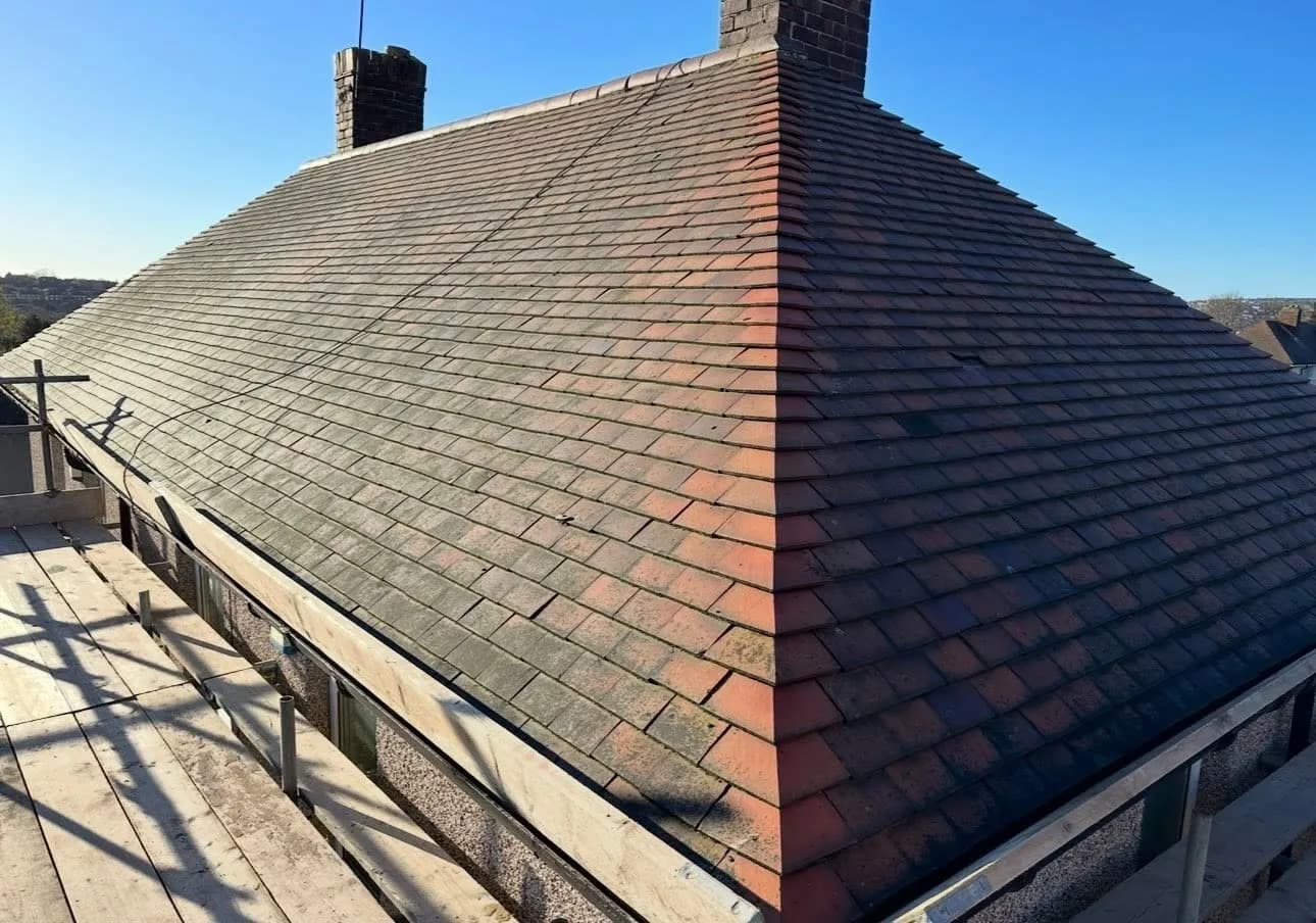 The old roof before work started, with weathered red tiles