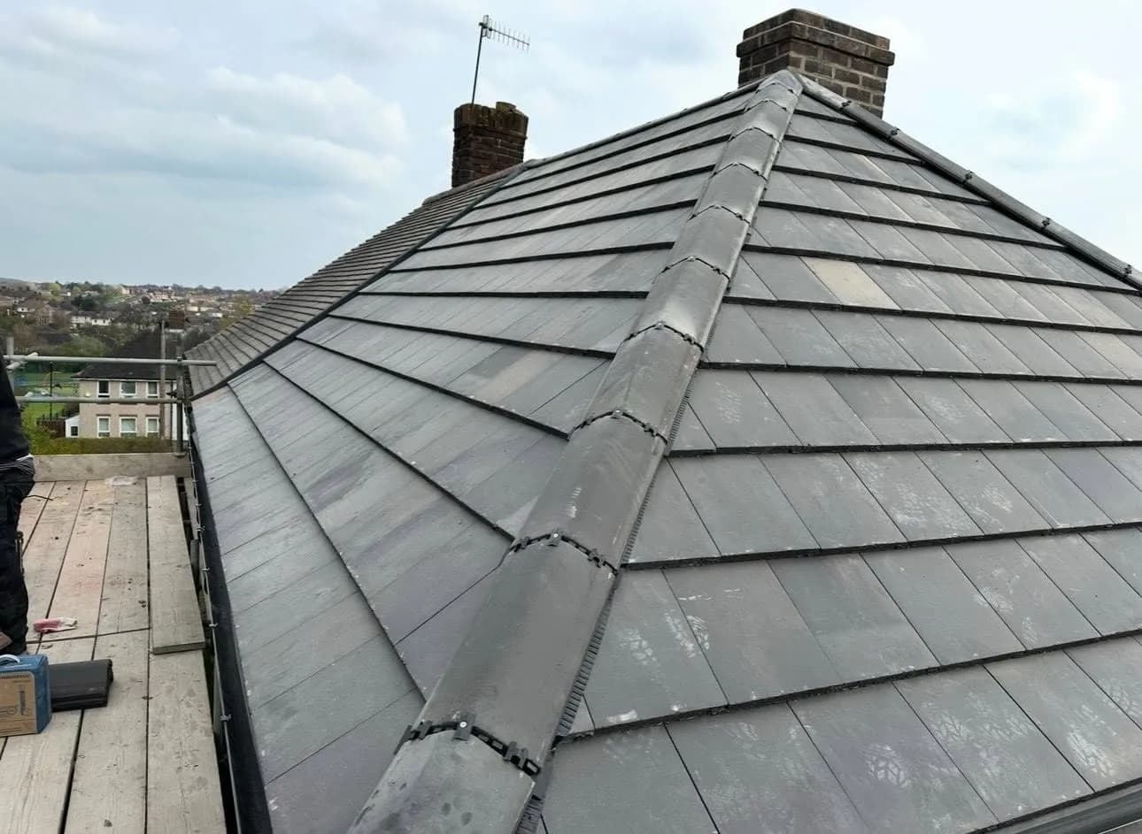 A hipped roof finished in new grey tiles with new ridge tiles